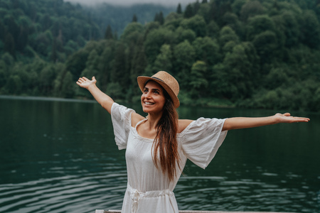 Summer girl portrait. Asian woman smiling happy on sunny summer or spring day outside in park by lake.の写真素材