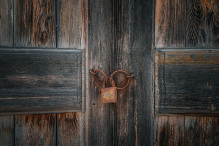 Old rusty lock on the brown vintage wooden door.の写真素材