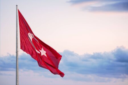 Turkey Flag surges above a cloudy evening sky.