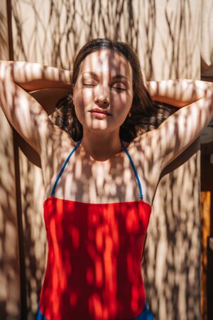 Young woman, sunbathing under shadow of a palm.の写真素材