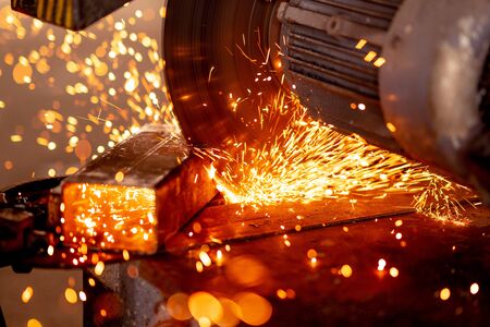 Cutting industrial metal with grinder. Sparks while grinding iron.