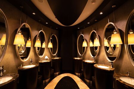 A modern decorated, public restroom with mirrors in a luxury restaurant or hotel.の写真素材