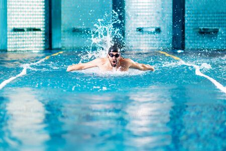 professional swimmer doing exercise in indoor swimming pool.の写真素材