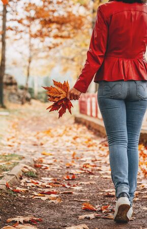 young woman walking on a path in forest enjoing the fall season.の写真素材