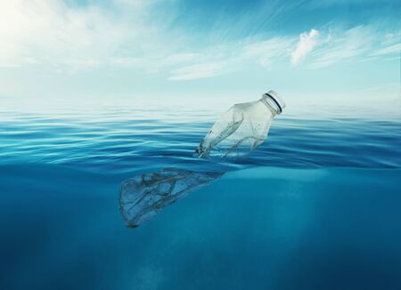 a discarded plastic rubbish bottle floats underwater on a presenting a hazard to all marine life.
