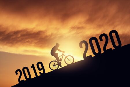 2020 new year concept with the silhoutte of a bicycle rider, metmorphing the changes of years.の写真素材
