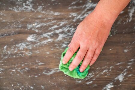 Woman is wiping the dirty glass surface for hygiene.