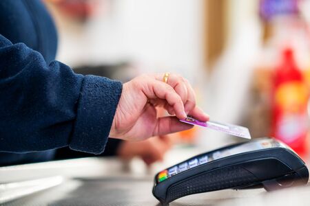 Close up of cashier is using contactless credit card pos terminal to getting the payment
