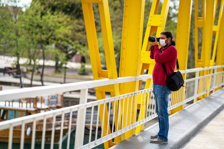 A photographer journalist shoot to reckless people on crowded street with a mask in a quarantine period because of pandemic global dangerの写真素材