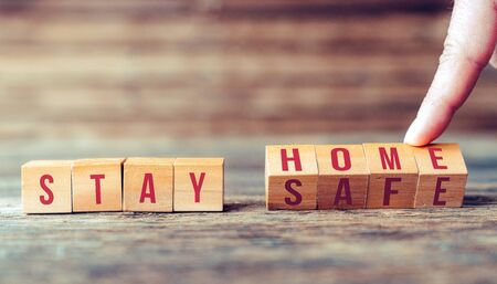 Announcement with wooden blocks to people, to stay at home to keep social distance