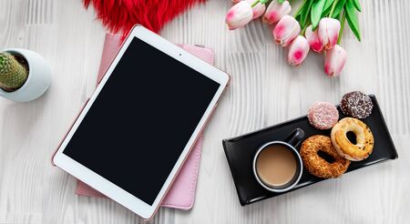 Tablet on a nice decorated white wooden table background. Styled design photography. Textures and mockup conceptの写真素材