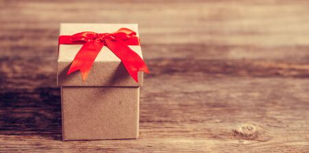 gift box on wooden table with shiny heart shaped lights