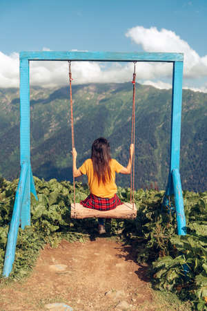 Beautiful woman swinging on a swing at high mountains enjoying the idyllic scene of the landscape. Beautyful forest and hiking destinations in Turkeyの写真素材