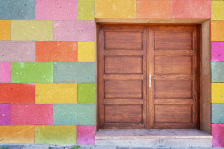 Old vintage brown painted wooden door and colorful painted blocks on wall. High quality photoの写真素材