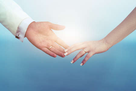 Bride and groom hands together and fingers touching eachother with wedding ring as a symbol of bonding. High quality photoの写真素材