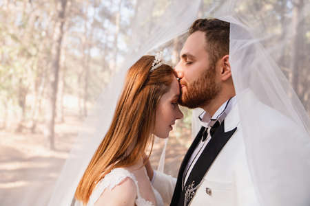 Bride and groom together, and looking eachother with fascinated wide open eyes. Wedding concept. High quality photoの写真素材