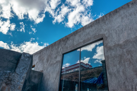 Huge window of a industrial building or depot above the blue sky with plufy clouds. High quality photoの写真素材