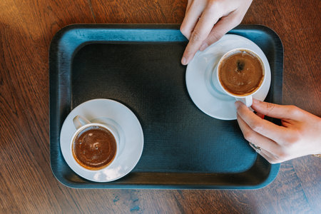 Hands holding coffee cups on a tray. High quality photoの写真素材