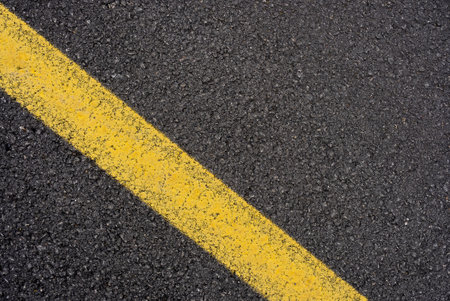 Close-up asphalt road texture with yellow line. High quality photoの写真素材