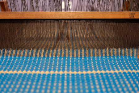 Vintage blue thread behind a manual wood loom, old style weaving loom. High quality photo