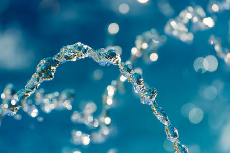 Water splash with water droplets on a shiny blue bokeh background. High quality photo