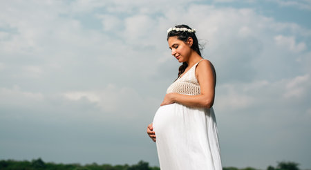 Portrait of pregnant woman with white dress. High quality photo