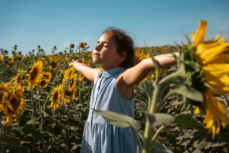 Beautiful little girl in yellow garden of sunflowers. High quality photoの写真素材