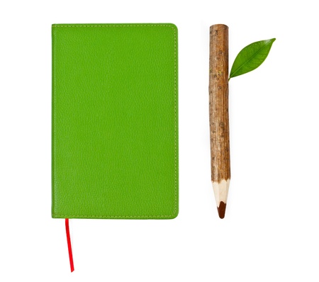 green notebook and wooden pencil isolated on white backgroundの写真素材