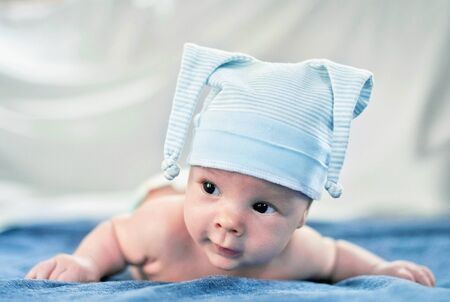 The child in a funny hat looks at the camera.の写真素材