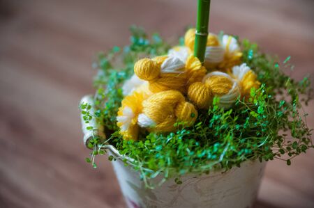 Easter decor of chicks and spring grass. Knitted chickens on the grass. Handmade chicken in a vintage pailの写真素材