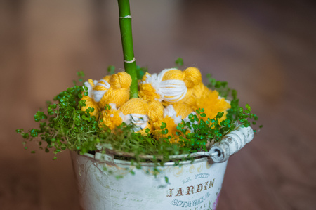 Easter decor of chicks and spring grass. Knitted chickens on the grass. Handmade chicken in a vintage pailの写真素材