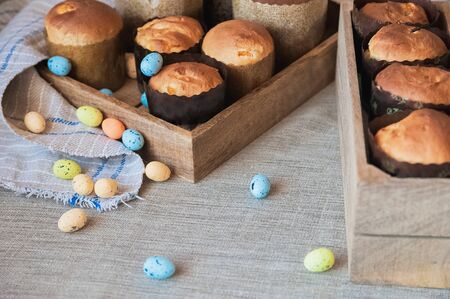 Beautiful Easter cakes and pasks on a wooden tray with colorful eggs and willows