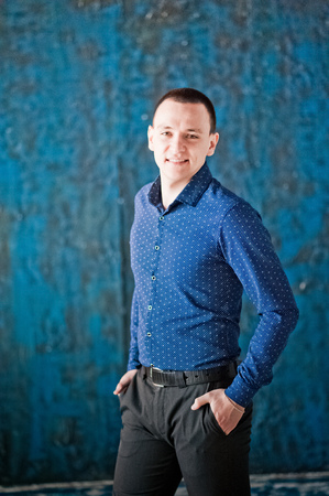 Portrait of a man in a blue shirt on a blue background. Portrait of a man who pondered, pendingの写真素材