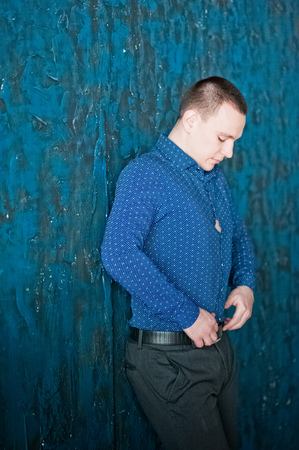 Portrait of a man in a blue shirt on a blue background. Portrait of a man who pondered, pendingの写真素材