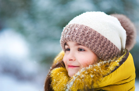 Beautiful winter portrait of a child outdoors. Face of girl closeup with snowflakes on eyelashesの写真素材