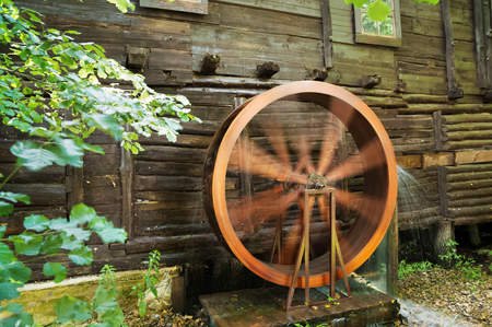 The wheel of the windmill is spinning and running water. An old water mill. Saratov, Loch, Russia