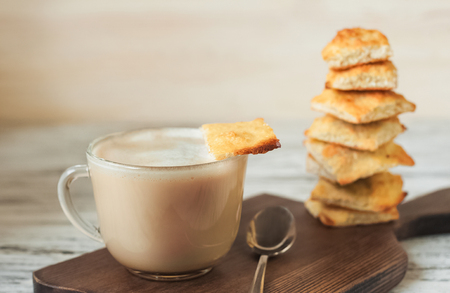 Appetizing picture of food, a cup with fragrant coffee, mocha, milk on a turret background of a square homemade cookieの写真素材