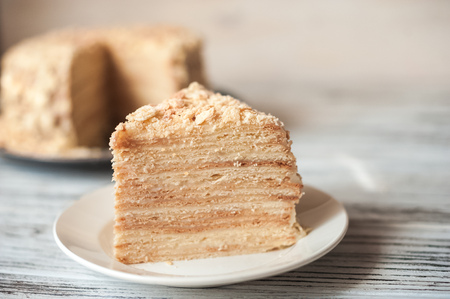 Beautiful appetizing homemade puff cake Napoleon. Piece of puff pastry on a white plateの写真素材