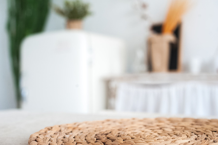 The white textured kitchen is blurred in the background in the style of shabby. A large table in an ecological style and loft style. Rustic napkins, wicker baskets, diyの写真素材