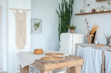 White textured kitchen in the style of shabby. A large textured table in the ecological style and Loft style. Rustic wicker napkins, light green tablecloth, diy.の写真素材