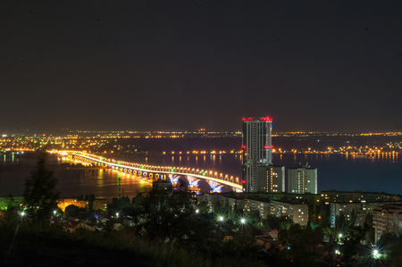 Moon eclipse. View of the night city of Saratov, Russia. The lights of a metropolis in the night. View of the bridge over the Volga River.の写真素材