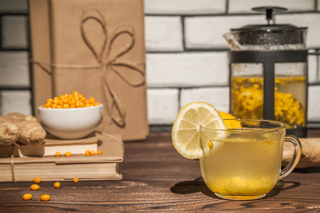 Sea buckthorn tea on a dark wooden textural background. Sea bangthorn, lemon, gingerの写真素材