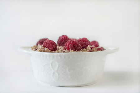 Oatmeal with raspberries in a white plate