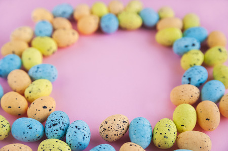 Patterned colorful painted eggs on a pink background. Easter concept.