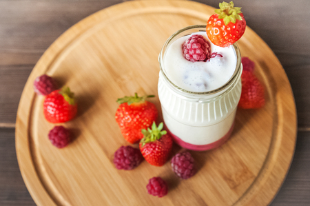Milk yogurt on a round wooden boardの写真素材