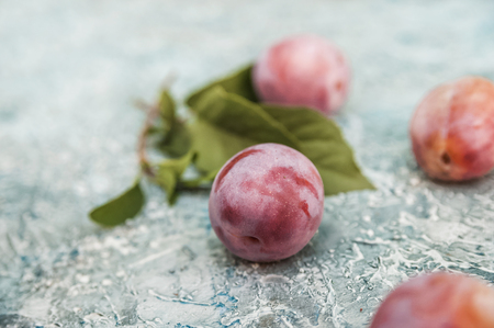 Natural texture of homemade fruit. Ripe juicy plums on a blue background close up and save spaceの写真素材