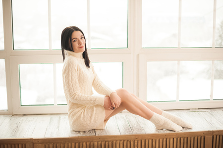 Girl in scandinavian interior by the windowの写真素材