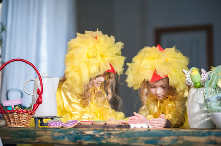 Easter eggs, ginger cookies, painted eggs, laugh. Girls in the kitchen in costumes chicken.