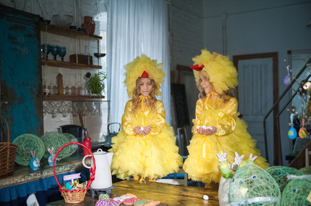 Easter eggs, ginger cookies, painted eggs, laugh. Girls in the kitchen in costumes chicken.の写真素材