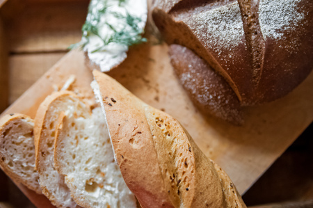 Sliced baguette and round rye black bread. Sandwich with bread, butter and dill. White loaf and rye...